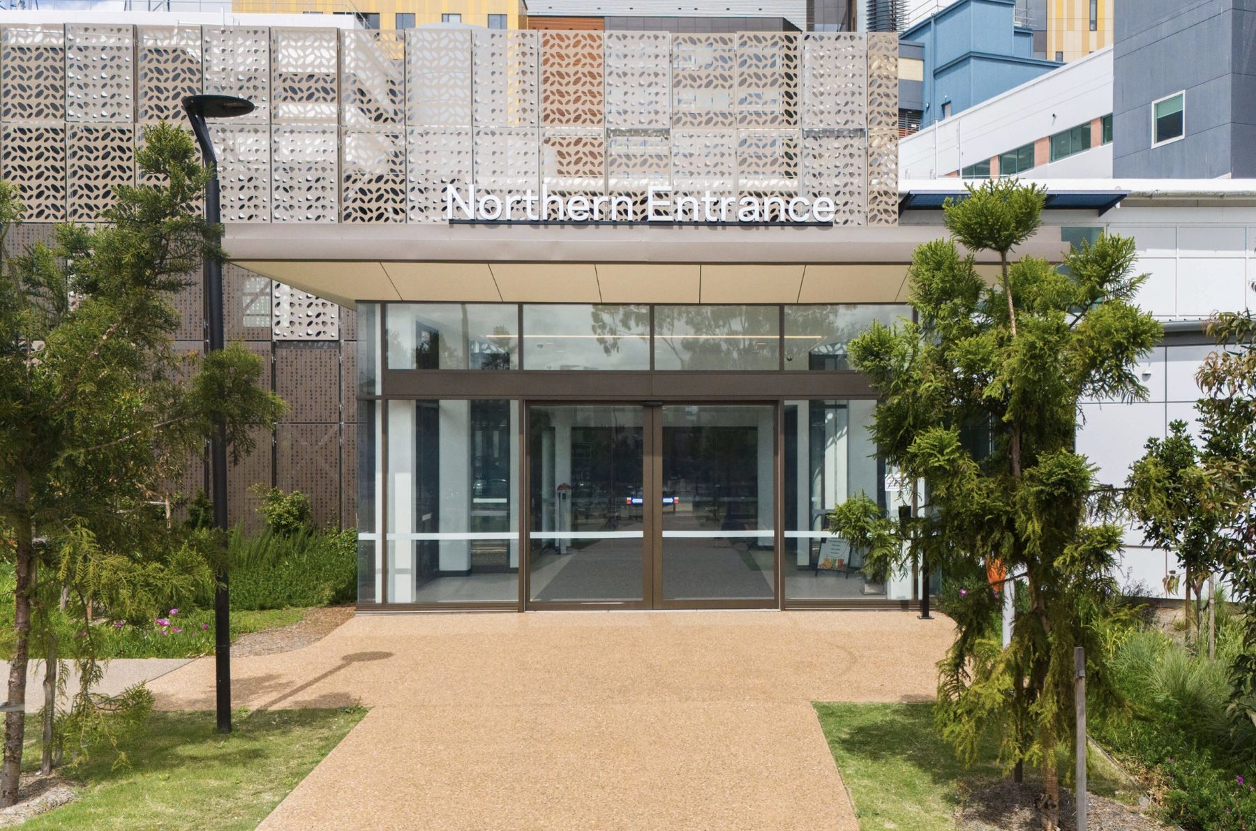Northern entrance of a hospital building with perforated metal facade screen
