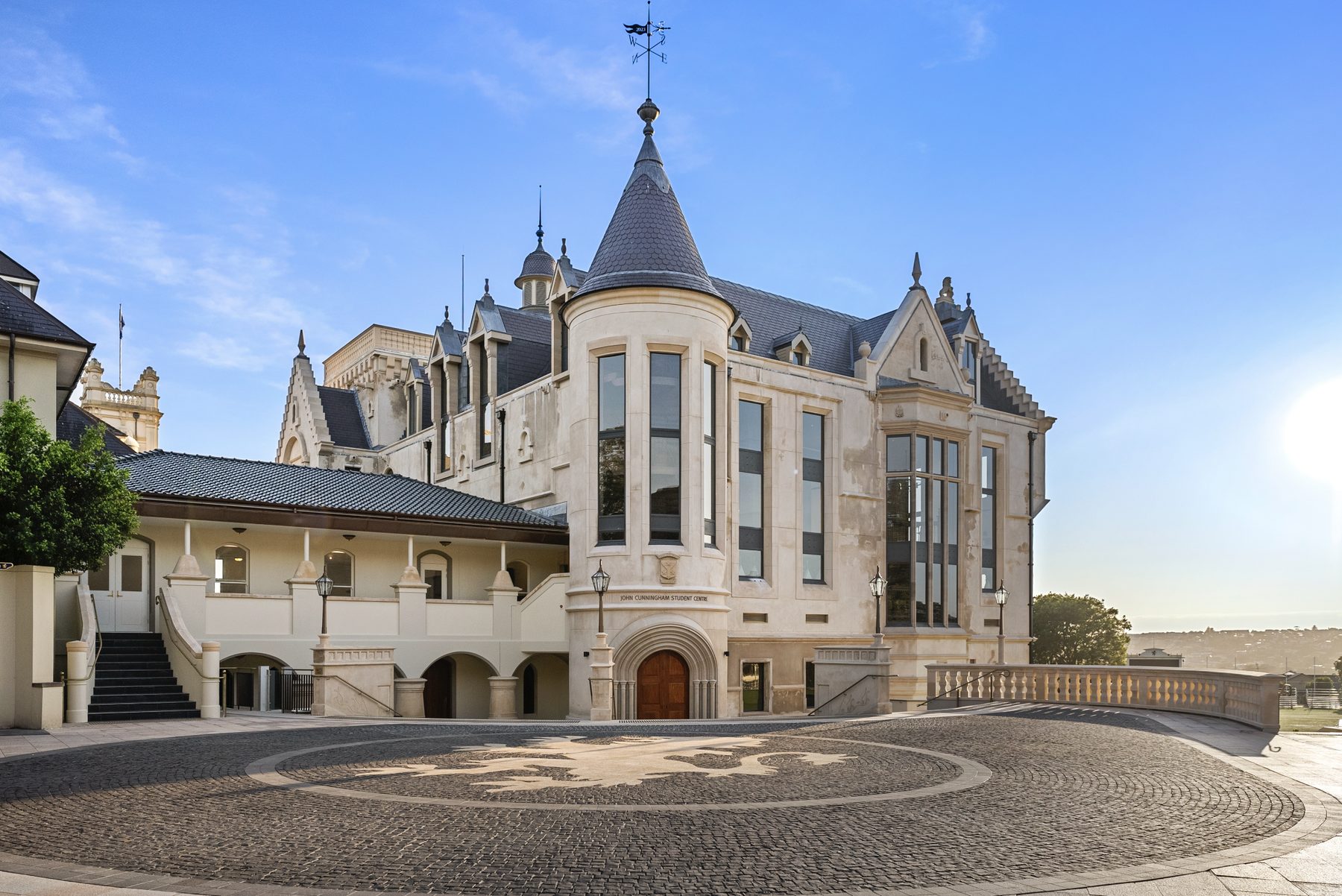 Entrance turret of a heritage stone building with cobblestone forecourt
